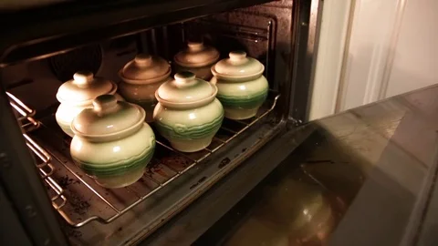 Pots of stew in the oven Stock Footage 76583712