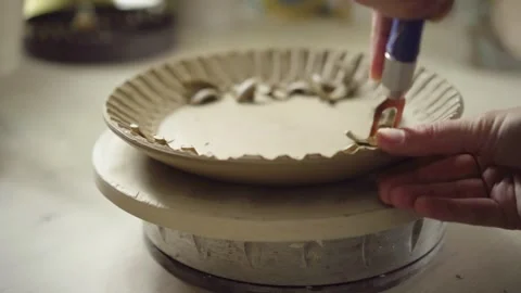 Potter adding decorative details to plate Stock Footage 308938424