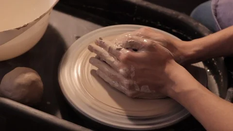 Potter creates the product on a potter's wheel, working with clay, forming a jug Stock Footage
