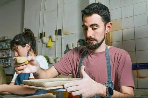Potter creating ceramics in workshop with clay and slab roller Stock Photos