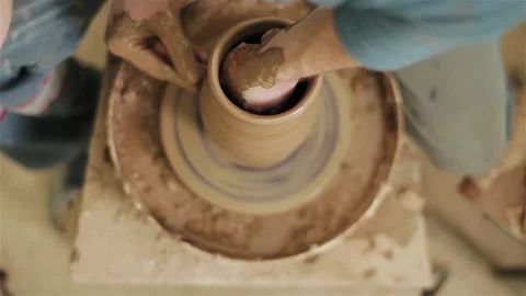 Potter creating clay jar vase earthenware on twisting wheel top view indoors  動画素材 87344769