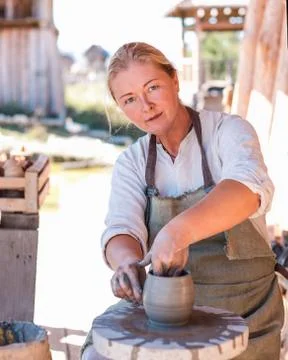 Potter is creating earthenware on potter's wheel. Stock Photos