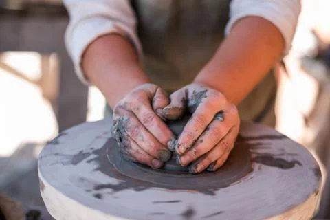 Potter is creating earthenware on potter's wheel. Stock Photos