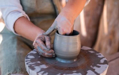 Potter is creating earthenware on potter's wheel. Stock Photos