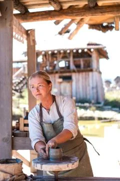 Potter is creating earthenware on potter's wheel. Stock Photos
