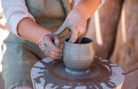 Potter is creating earthenware on potter's wheel. Stock Photos