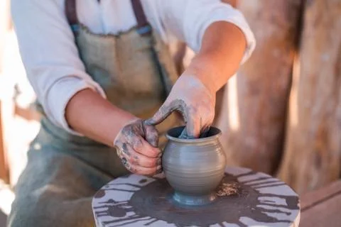 Potter is creating earthenware on potter's wheel. Stock Photos