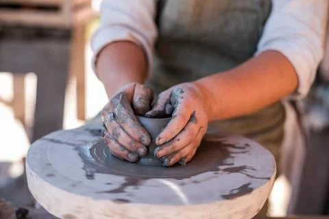 Potter is creating earthenware on potter's wheel. Stock Photos