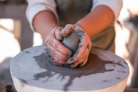 Potter is creating earthenware on potter's wheel. Stock Photos
