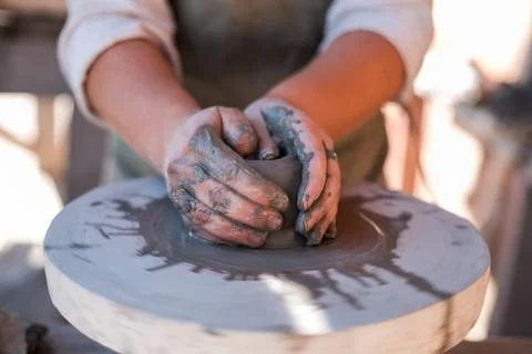 Potter is creating earthenware on potter's wheel. Stock Photos