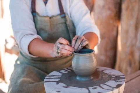 Potter is creating earthenware on potter's wheel. Stock Photos