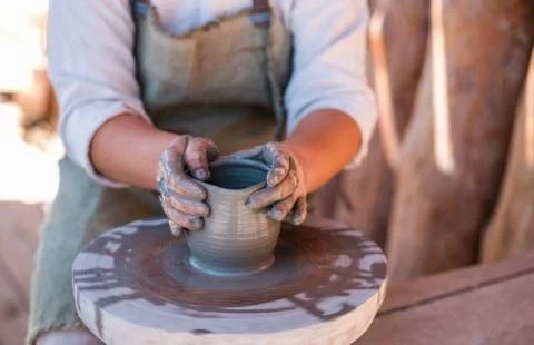 Potter is creating earthenware on potter's wheel. Stock Photos