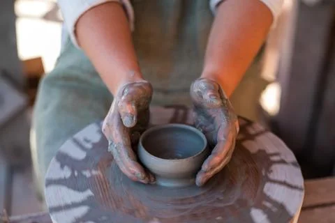 Potter is creating earthenware on potter's wheel. Stock Photos