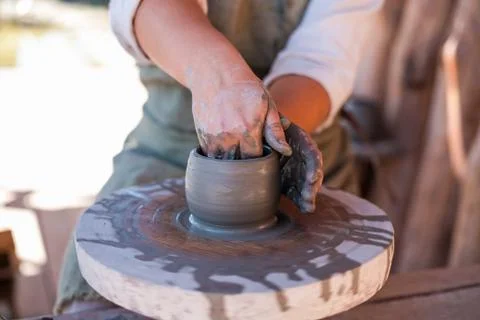 Potter is creating earthenware on potter's wheel. Stock Photos