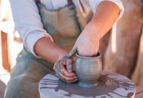 Potter is creating earthenware on potter's wheel. Stock Photos