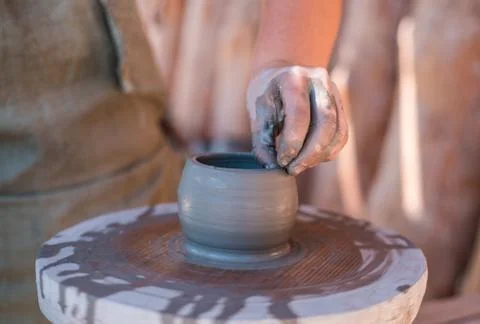 Potter is creating earthenware on potter's wheel. Stock Photos