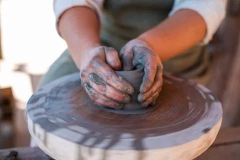 Potter is creating earthenware on potter's wheel. Stock Photos