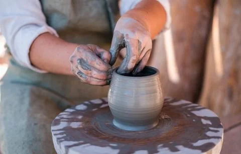 Potter is creating earthenware on potter's wheel. Stock Photos