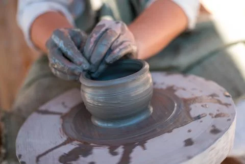 Potter is creating earthenware on potter's wheel. Stock Photos