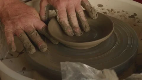 Potter Creating Pattern on Spinning Clay Plate with Hands Close-Up Stock Footage 317939794