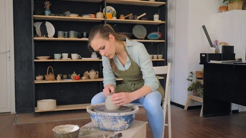 Potter cuts off excess clay. Creating cup of white clay Stock Footage 119543586