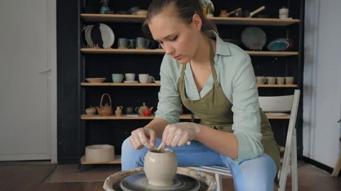 The potter cuts the top of the cup with a line. Creating cup of white clay Stock Footage 119542986