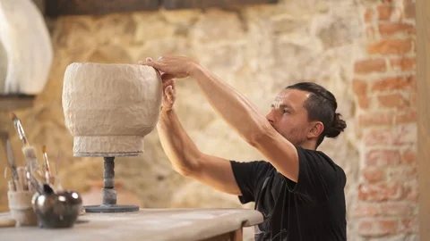 Potter is decorating ceramic pot. Inspired artist designing vase in workshop. Video stock 113080691