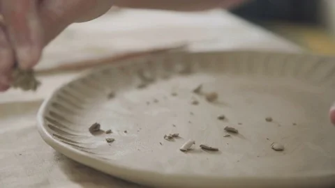 Potter does the clay pattern on the plate, using the stack Stock Footage 73230068