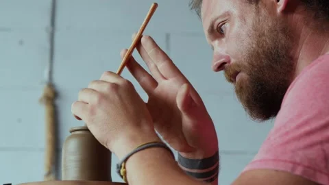 Potter forms a handle to the lid of a clay teapot on a potter's wheel. Vidéo 145543845