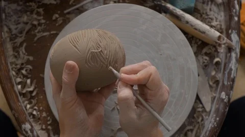 The Potter forms the pattern on a clay vase. The view from the top Stock Footage 127954989