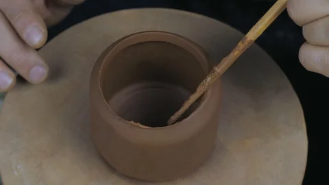 The potter greases the edges of the teapot to secure it to another part Stock Footage 120625856