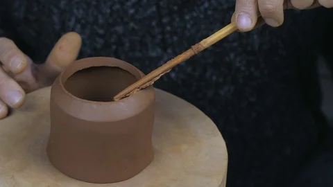 Potter greases the edges of the teapot to secure it to part of the teapot Stock Footage 120626019