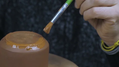 The potter greases the kettle with a brush to secure the lid. Handmade Stock Footage 120625924