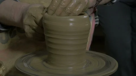 Potter with hands forming form of vase from clay, turning wheel and making pot. Stock Footage 57630832