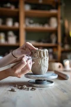 Potter hands shaping mug with loop tool, carve intricate pattern, scraping... Stock Photos