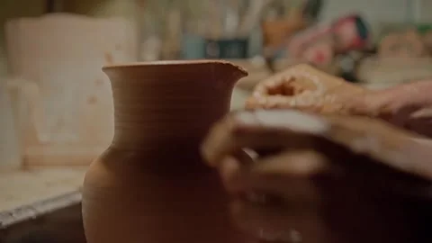 Potter makes a jug neck when it spinning on wheel. Craftsman lengthens a clay Stock Footage 264597056