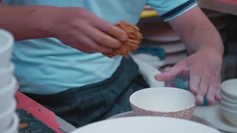 Potter making ceramic bowl tapping with a sponge on the surface. Stock Footage 296374706