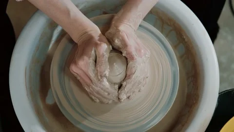 Potter making ceramic pot on the twisted pottery wheel. Top view. Woman making Stock Footage 152334528