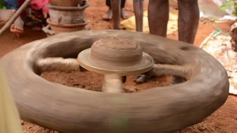 Potter making a clay pot on a mechanical, old style pottery wheel Stock Footage 159369411