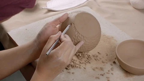 Potter making ornament on ceramic plate. Woman ceramist puts texture on the Stock Footage 107940140