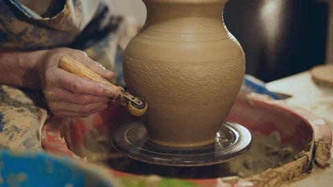 The potter making pattern on clay pitcher, using tool for it Stock Footage 104234618