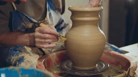 The potter making pattern on clay vase, using tool for it Stock Footage 104234546