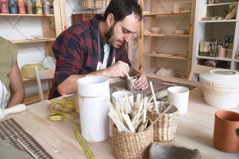 Potter man making a ceramic craft in workshop. Fotos Stock