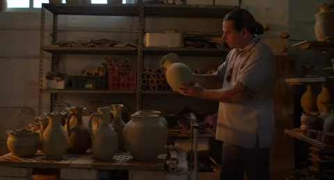 Potter puting a clay jug on a pushcart and pushes it towards the oven. Stock Footage 101288194
