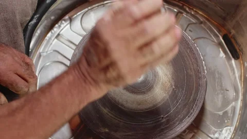 Potter puts piece of processed clay on clean potter's wheel with one hand and Stock Footage 157783787