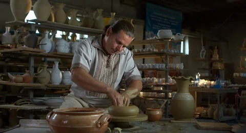 Potter rises a clay jug on a spinning wheel. Stock Footage 101288554