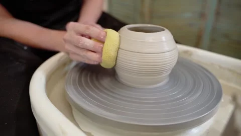 Potter shaping ceramic vase with sponge on pottery wheel 스톡 동영상 348029821