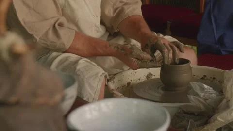 Potter Shaping Final Stage of Handmade Clay Mug on Pottery Wheel Close-Up Stock Footage 317939783
