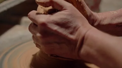 Potter shaping a raw clay on rotating wheel. Skilled craftsman showing Stock Footage 258256203