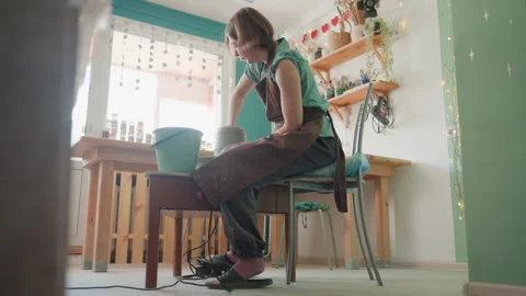 Potter shaping vessels in warm creative space. Artist carefully molds clay into Stock Footage 342286611